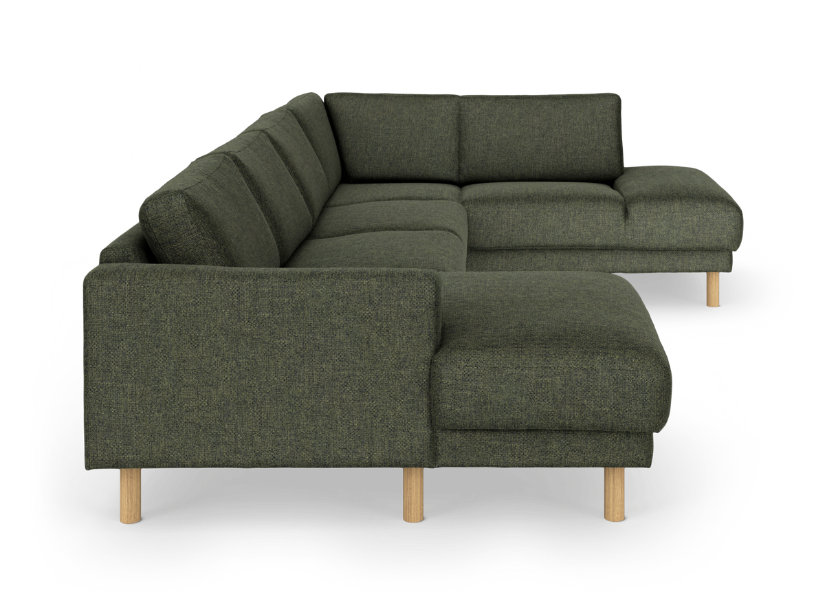 Mörkgrön modulsoffa i U‑form med ljusa träben, frilagd på vit bakgrund.