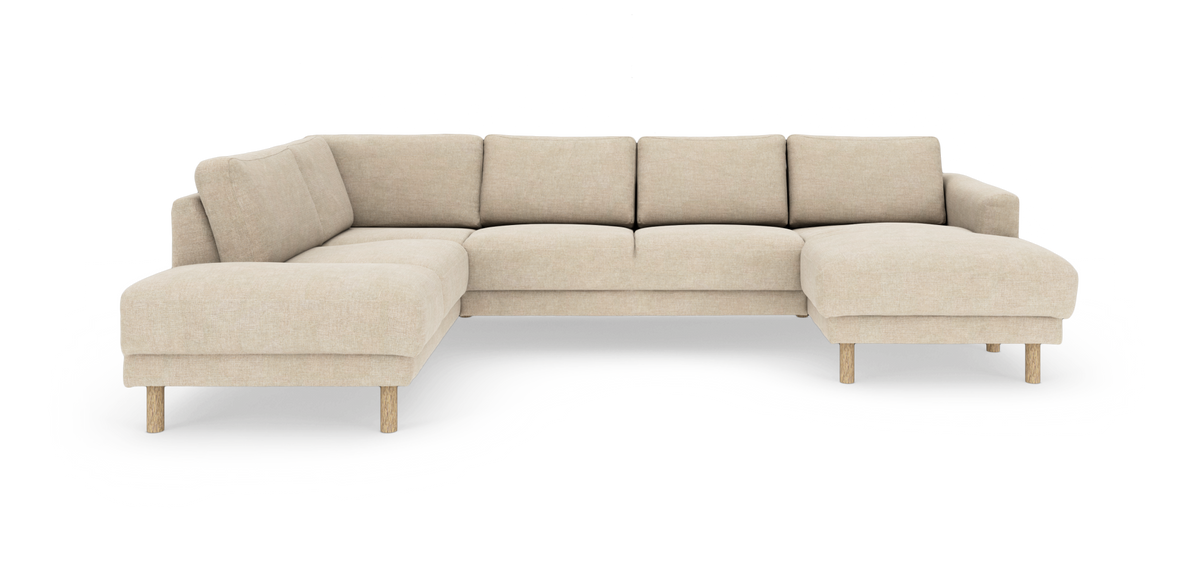 Beige hörnsoffa/sektionsoffa med schäslong, klädd i tyg och med runda träben, frilagd mot vit bakgrund.