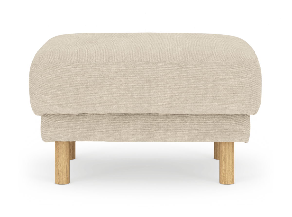 Beige fotpall med tygklädsel och runda ben i ljust trä, frilagd mot vit bakgrund.