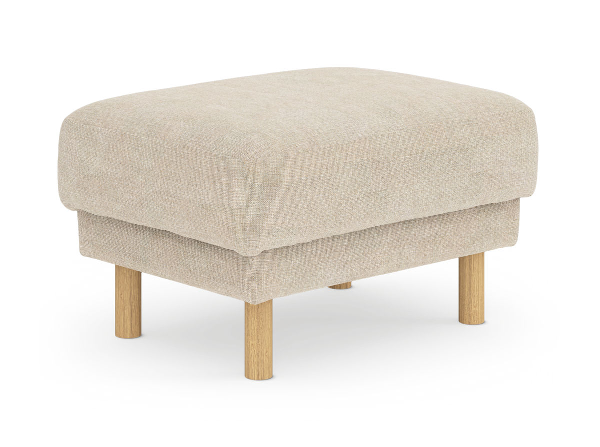 Beige stoppad fotpall/puff i tyg med runda ben i ljust trä, frilagd på vit bakgrund.