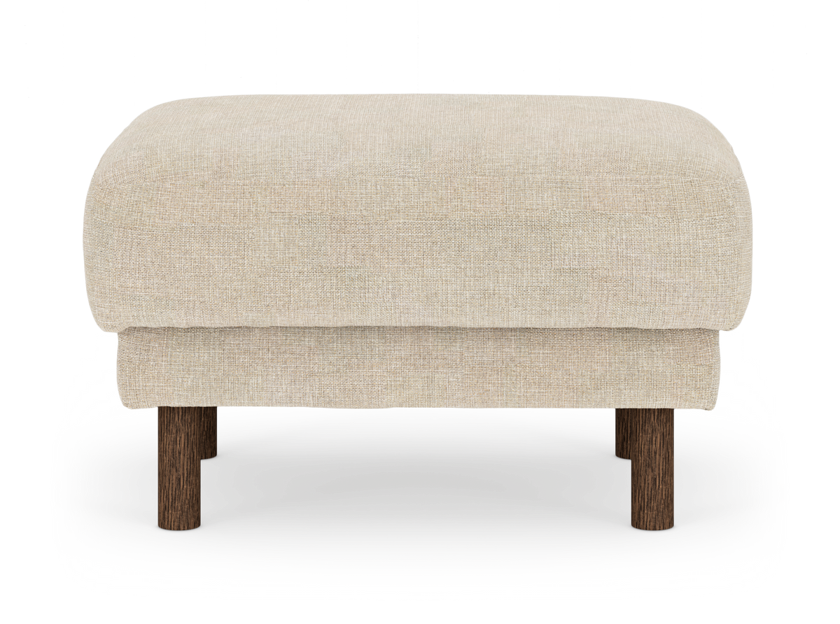 Beige sittpuff/ottoman i tyg med runda mörkbruna träben, frilagd mot vit bakgrund.