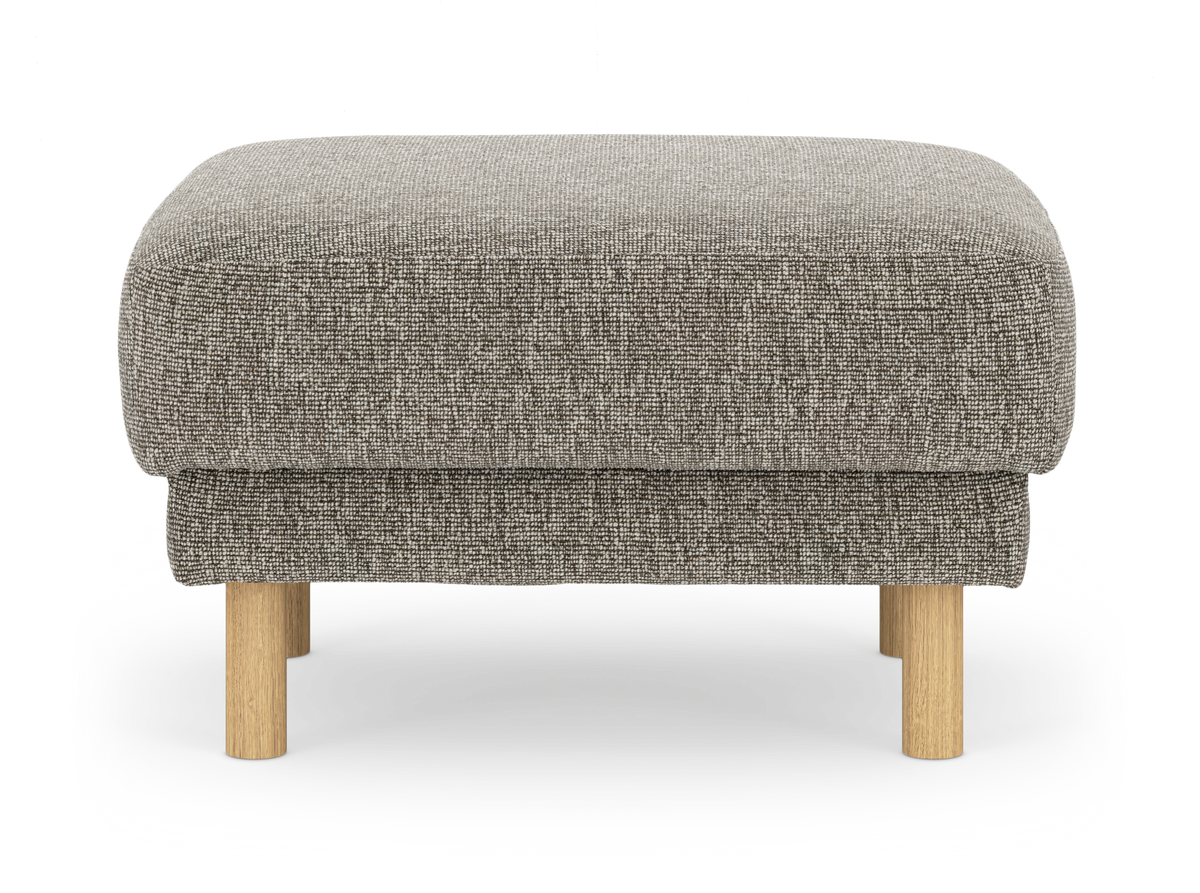Beige fotpall i tyg med runda träben, frilagd mot vit bakgrund.
