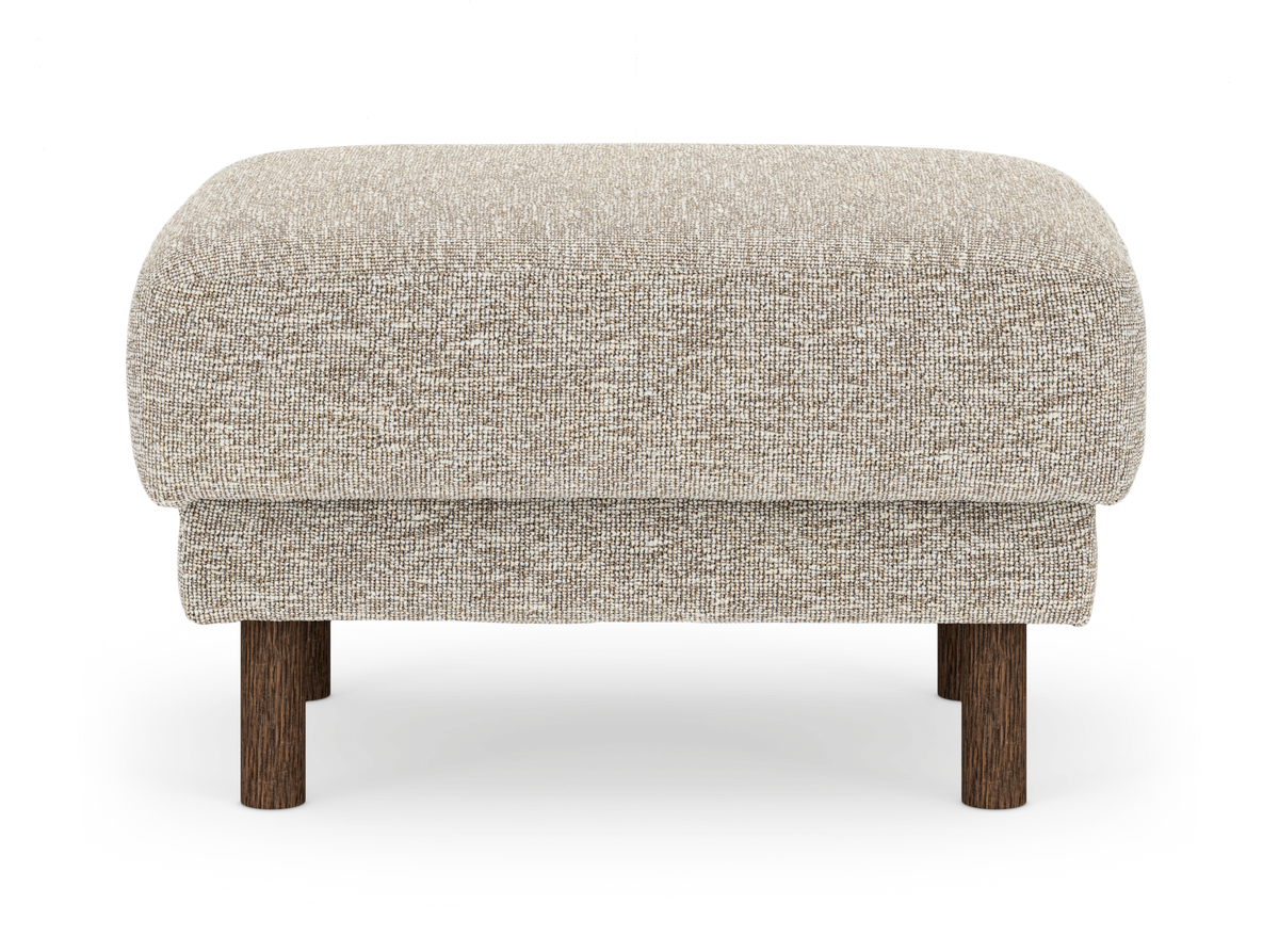 Beige stoppad puff/fotpall med runda träben, frilagd mot vit bakgrund.