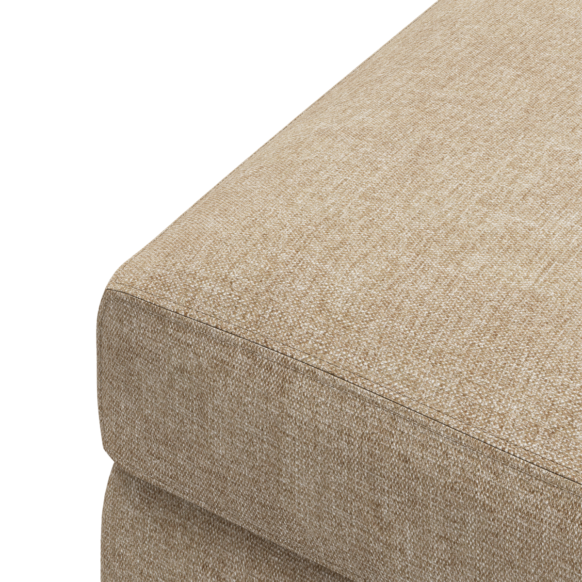 Närbild av beige tygklädd soff- eller pufmodul sedd från hörnet.