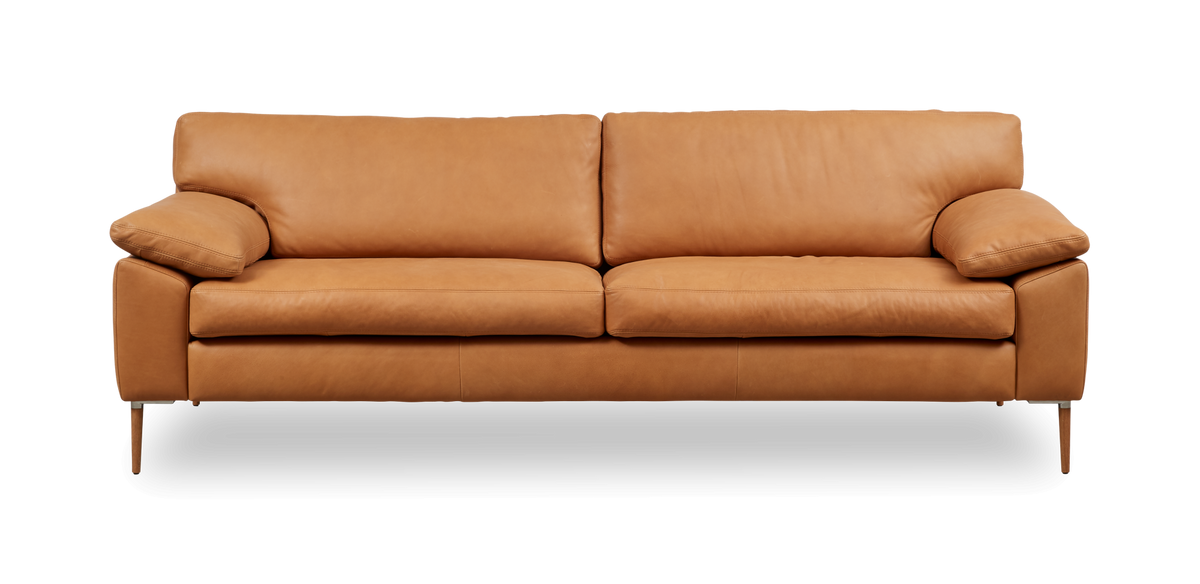 Kamelbrun lädersoffa med två sittdynor och smala ben, frilagd frontvy.