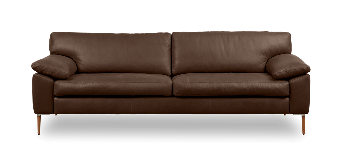 Brun lädersoffa med smala ben sedd framifrån på neutral bakgrund.