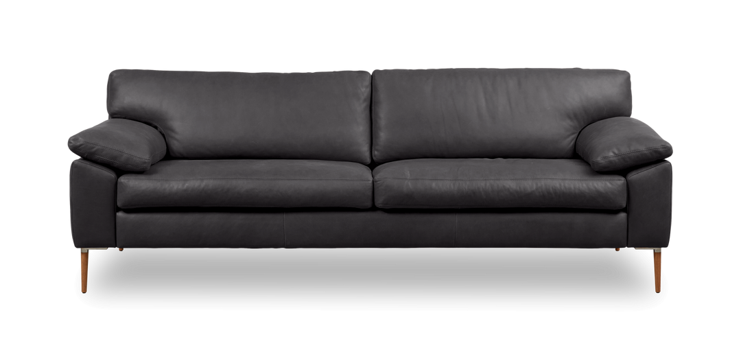 Mörkgrå tresitsig lädersoffa med smala träben, frontvy.