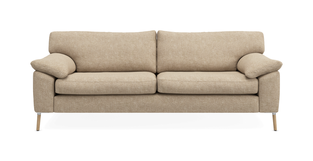 Beige tresitssoffa i tyg med mjuka kuddar och träben, fotad rakt framifrån på vit bakgrund.