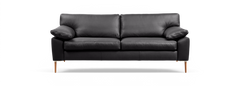 Svart lädersoffa med två sittkuddar, lösa ryggkuddar och träben, frilagd mot svart bakgrund.