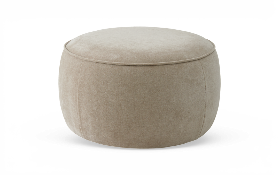 Beige rund puf/ottoman i tyg mot vit bakgrund.