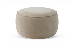 Beige rund puf/ottoman i tyg mot vit bakgrund.