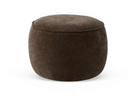 Rund mörkbrun stoppad puf/ottoman i studio, med mjuk textil i sammetliknande finish.