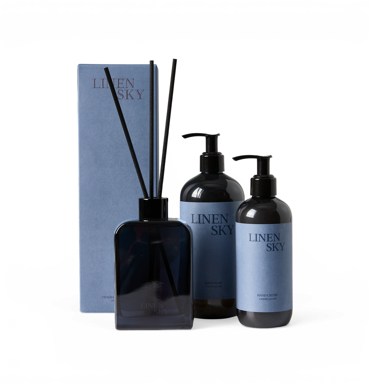 Set med LINEN SKY: doftpinnar (fragrance diffuser), HAND SOAP och HAND CREME i mörka flaskor med blå etiketter.