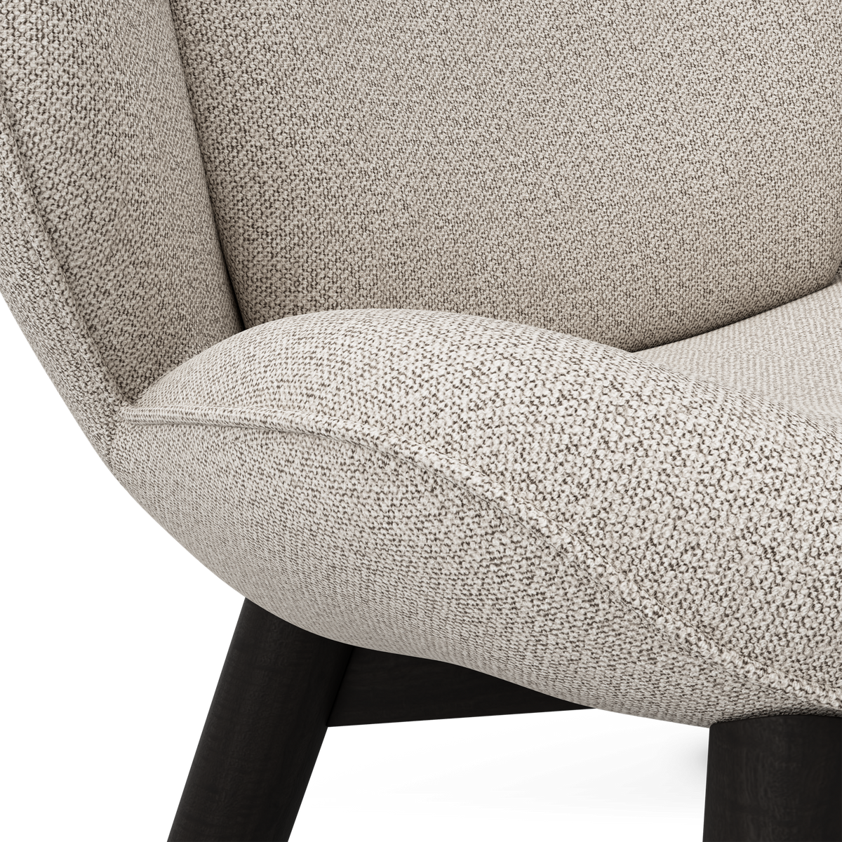 Närbild av beige melerad textil på en stoppad fåtölj med svarta träben.