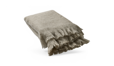 Vikt beige pläd med mjuka fransar mot mörk bakgrund.