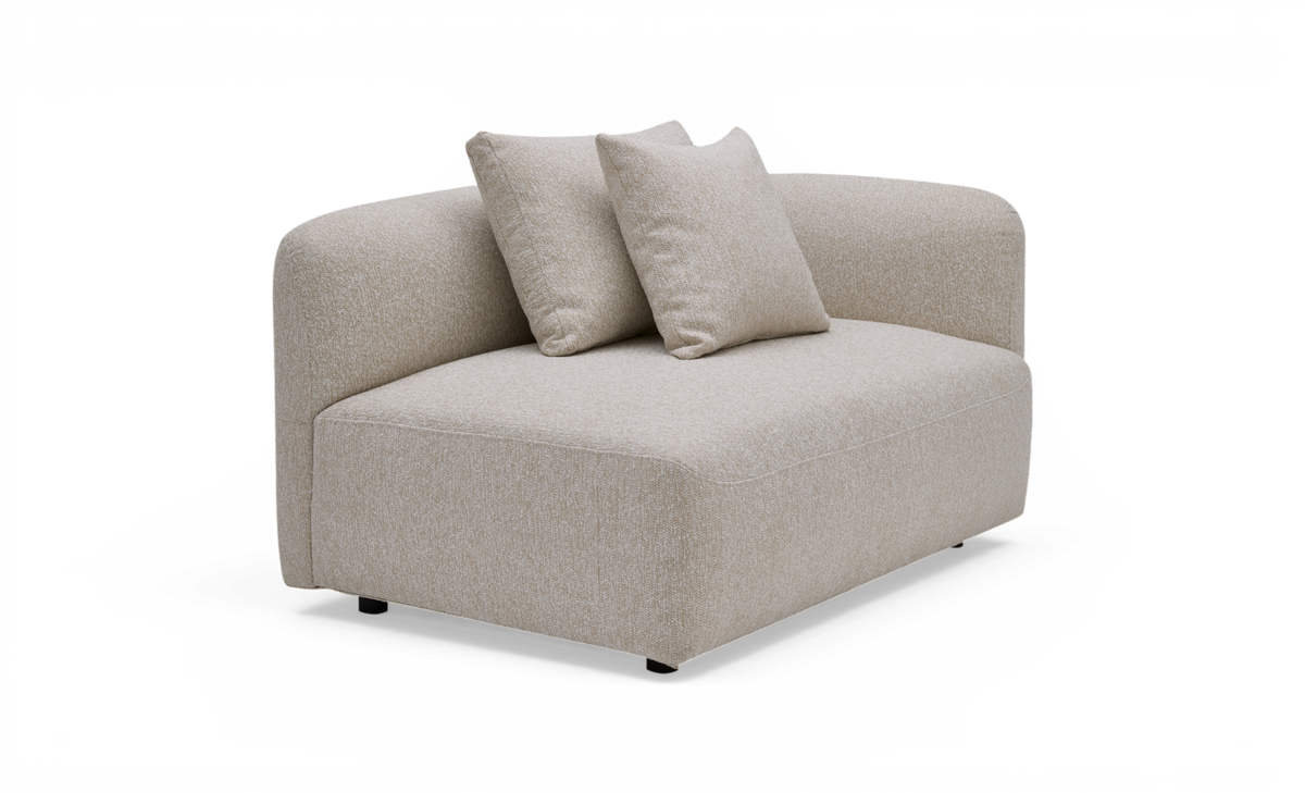 Beige modulsoffa i tyg med rundad rygg och två lösa kuddar, frilagd produktbild.