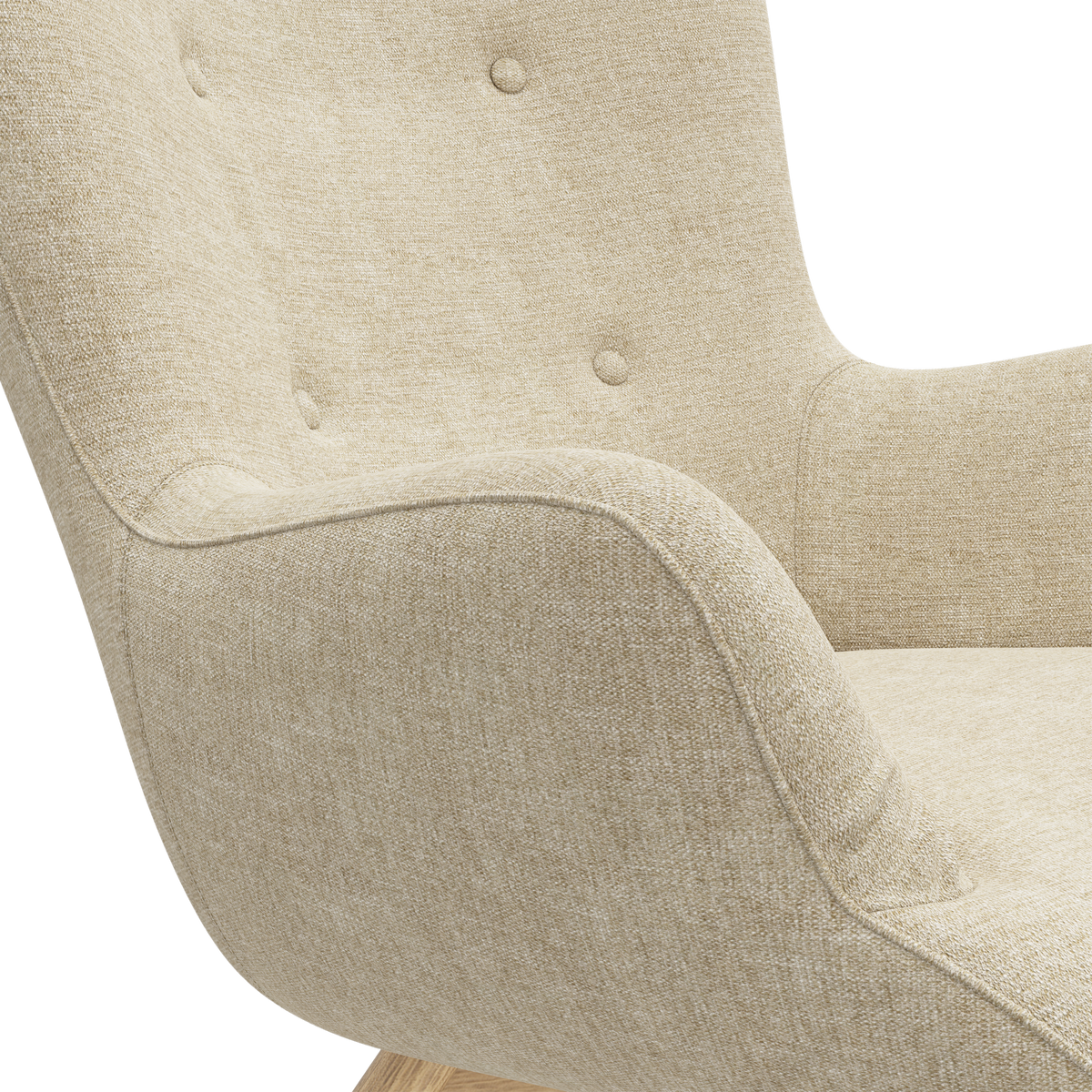 Närbild på beige tygfåtölj med knappar i ryggen och svängd arm; träbas skymtar.