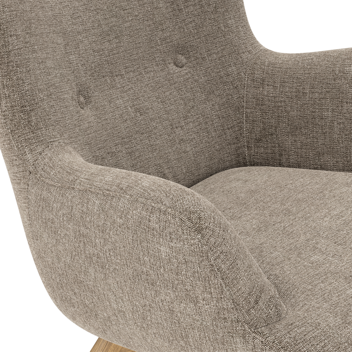 Närbild av en beige textilklädd fåtölj med knappar i ryggstödet och ljus träbas.