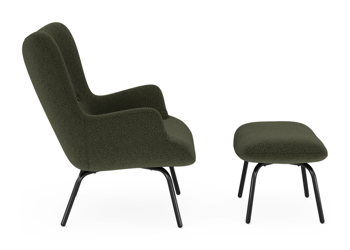Mörkgrön fåtölj i bouclé med matchande fotpall, svarta metallben, sedd från sidan på vit bakgrund.