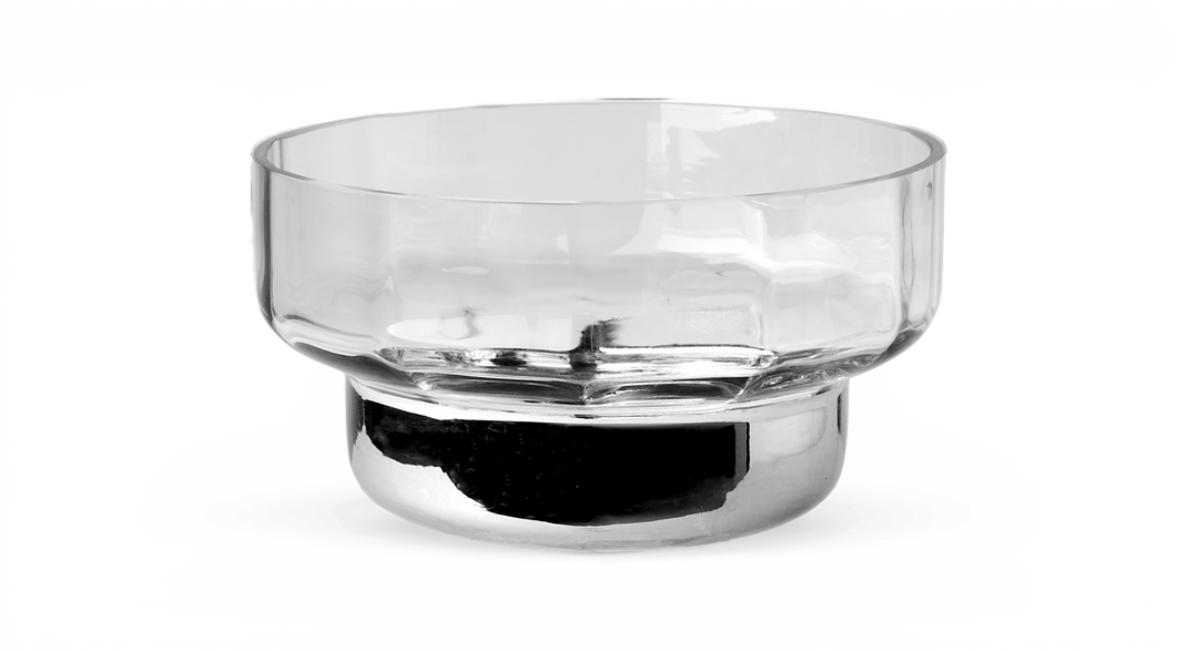 Transparent glasskål med bred öppning och cylindrisk fot, frilagd mot svart bakgrund.