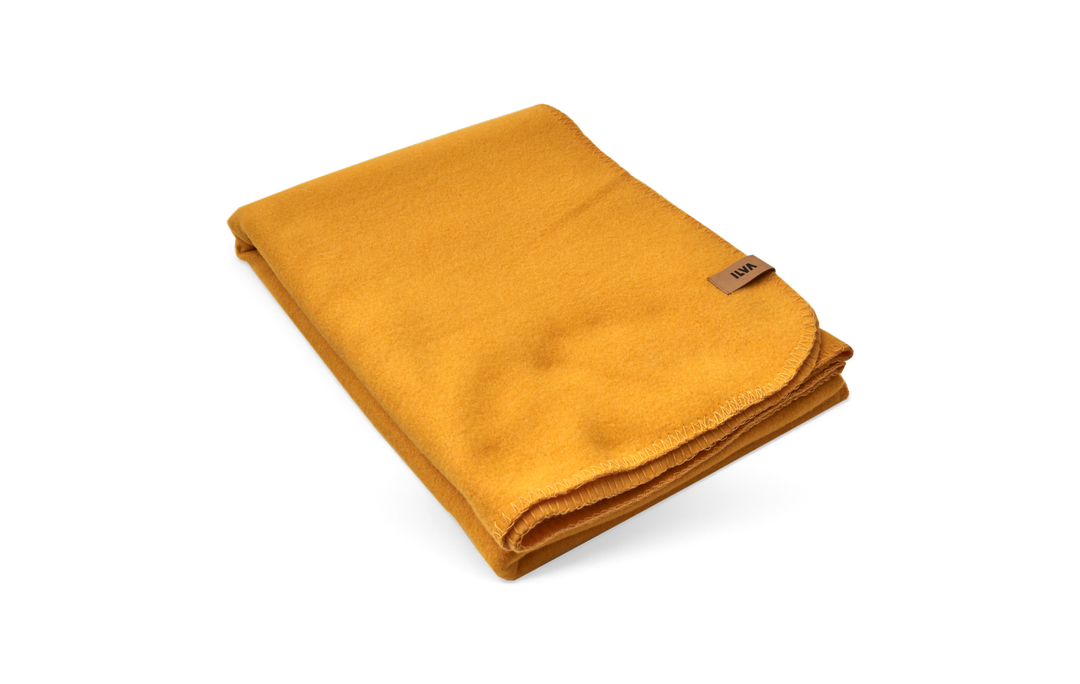 Beige rektangulär etikett med svart ILVA-logotyp på svart bakgrund.