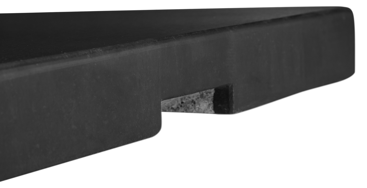 Närbild av svart stenskiva med urtag i kanten, mot vit bakgrund.