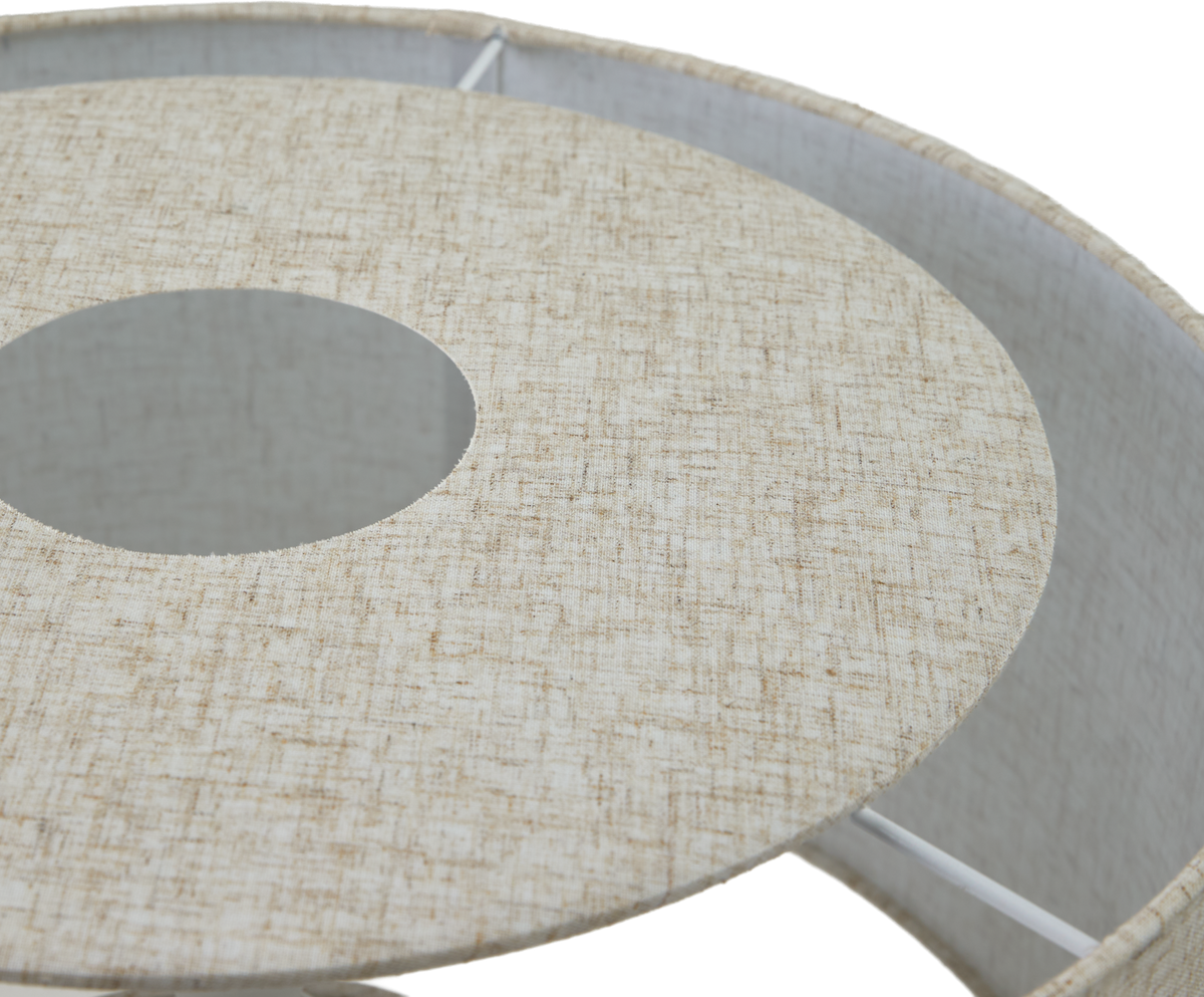 Närbild av beige textil lampskärm med cirkulärt hål och vita stag.