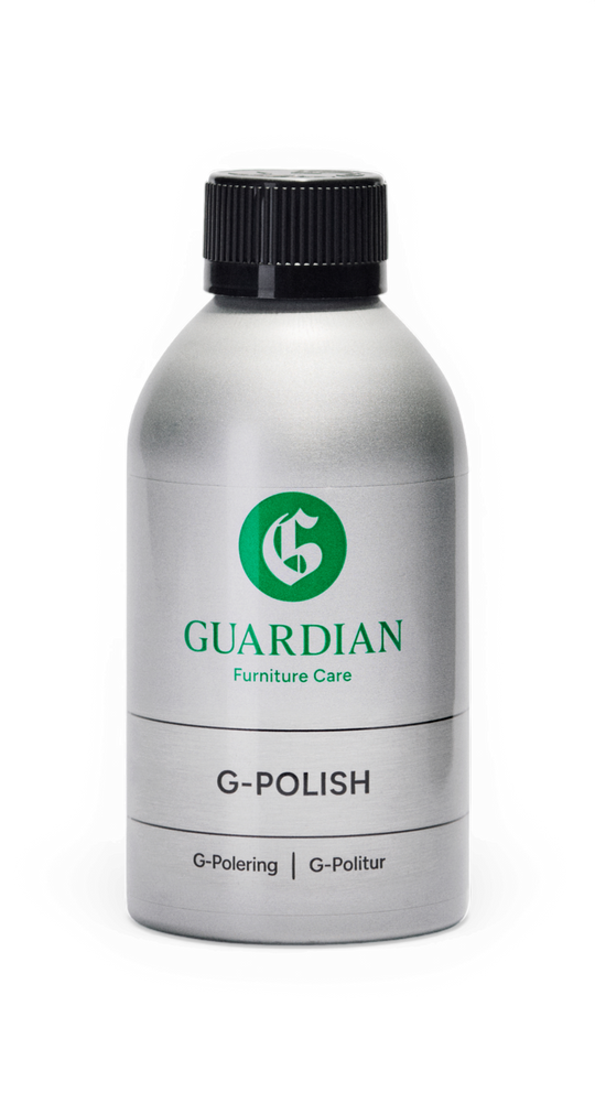Silverfärgad flaska med svart kork: Guardian Furniture Care G‑POLISH, märkt "G‑Polering | G‑Politur".