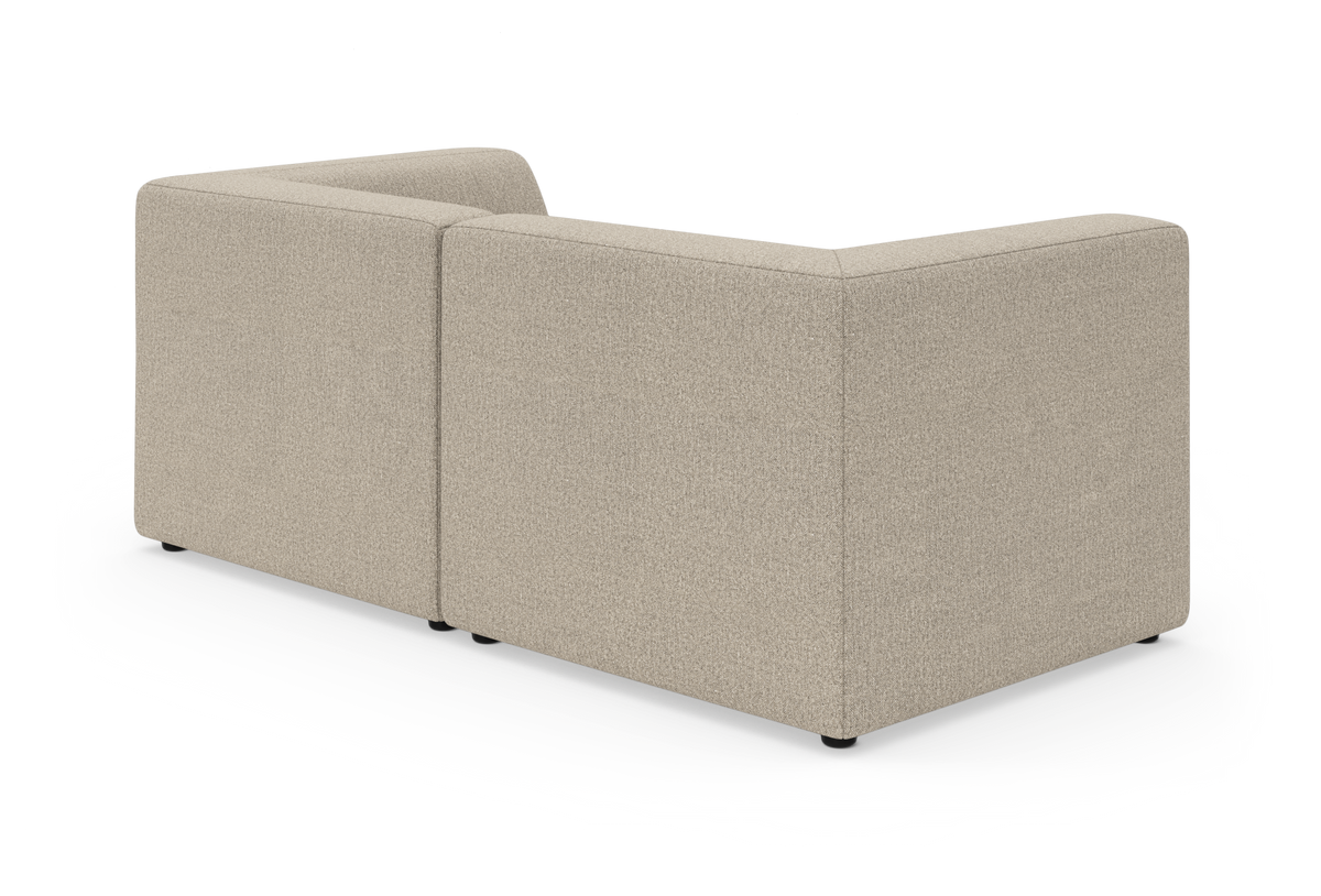 Beige L‑formad modulsoffa sedd bakifrån på vit bakgrund.