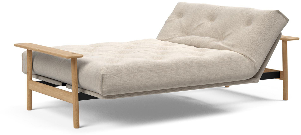 Beigefärgad futon/soffa med tuftad dyna och ljusa träarmstöd och ben på vit bakgrund.