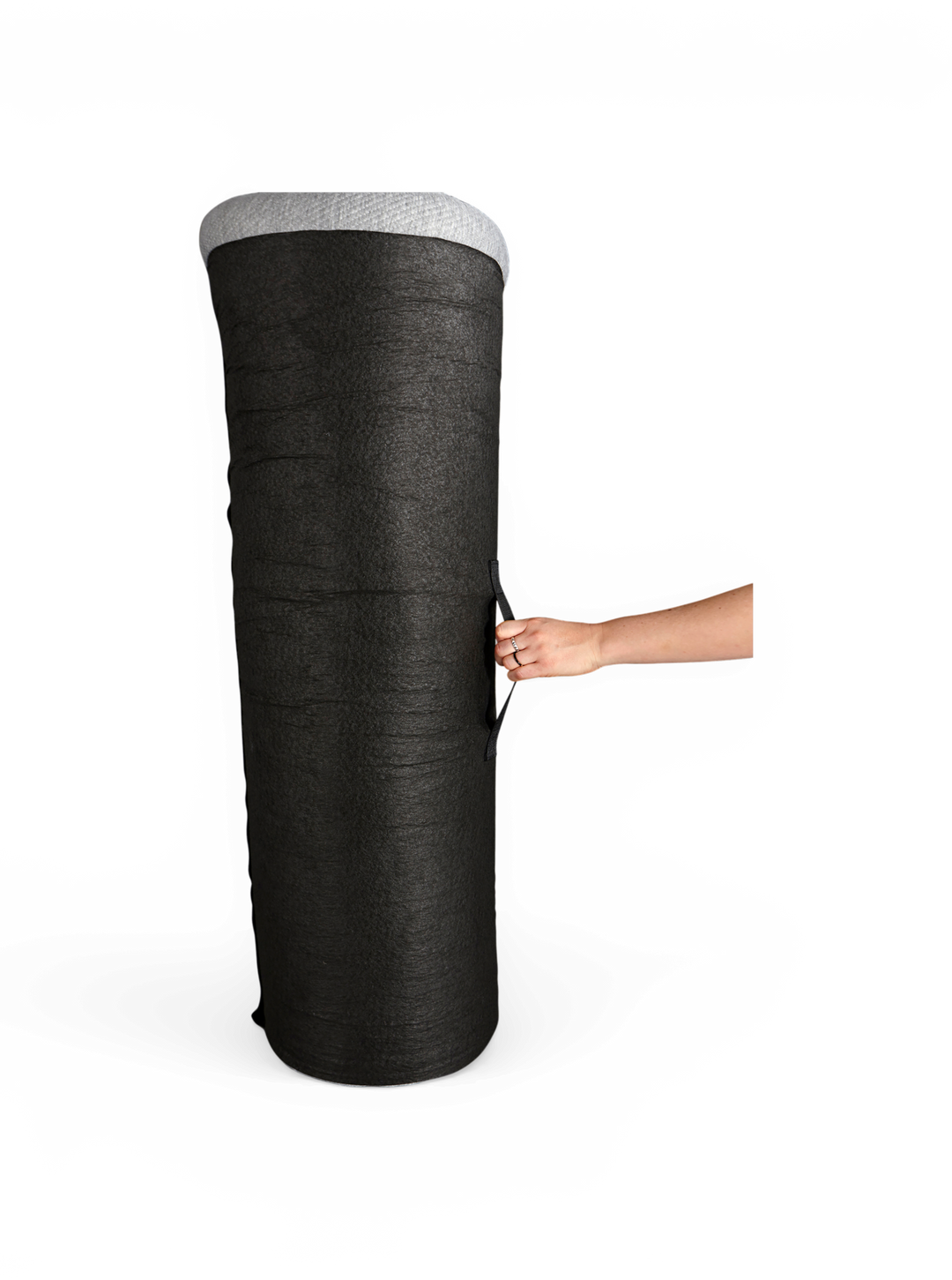 Stor svart cylindrisk odlingspåse med handtag, hålls i sidan av en hand på vit bakgrund.