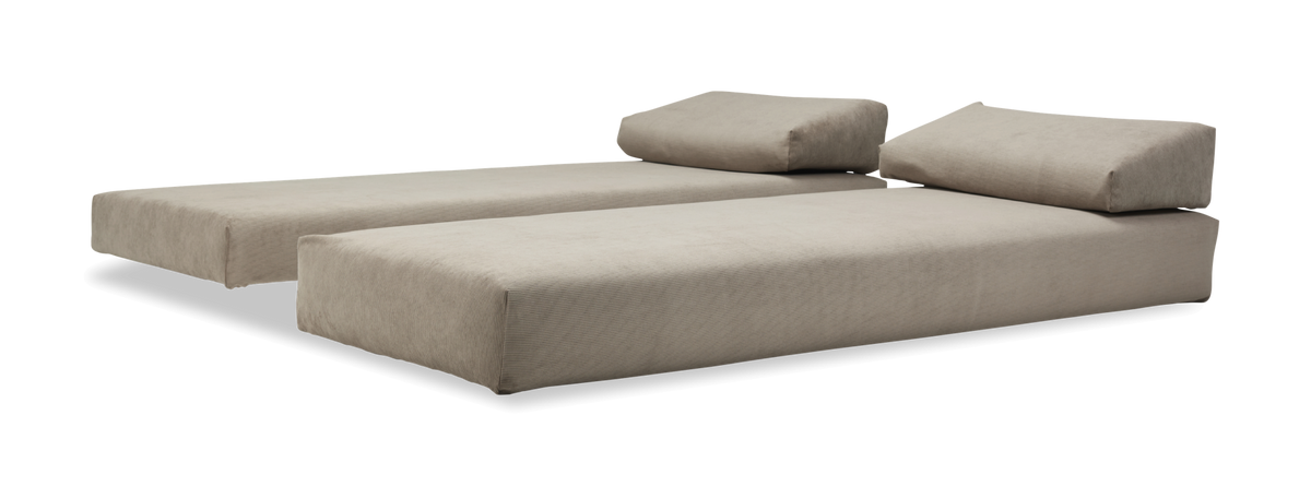 Två beige modulära schäslonger/soffdelar med lutande ryggkuddar.