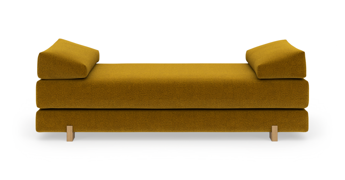 Sennepsgul dagbädd/soffa med lave armpuder, frilagd på vit bakgrund.