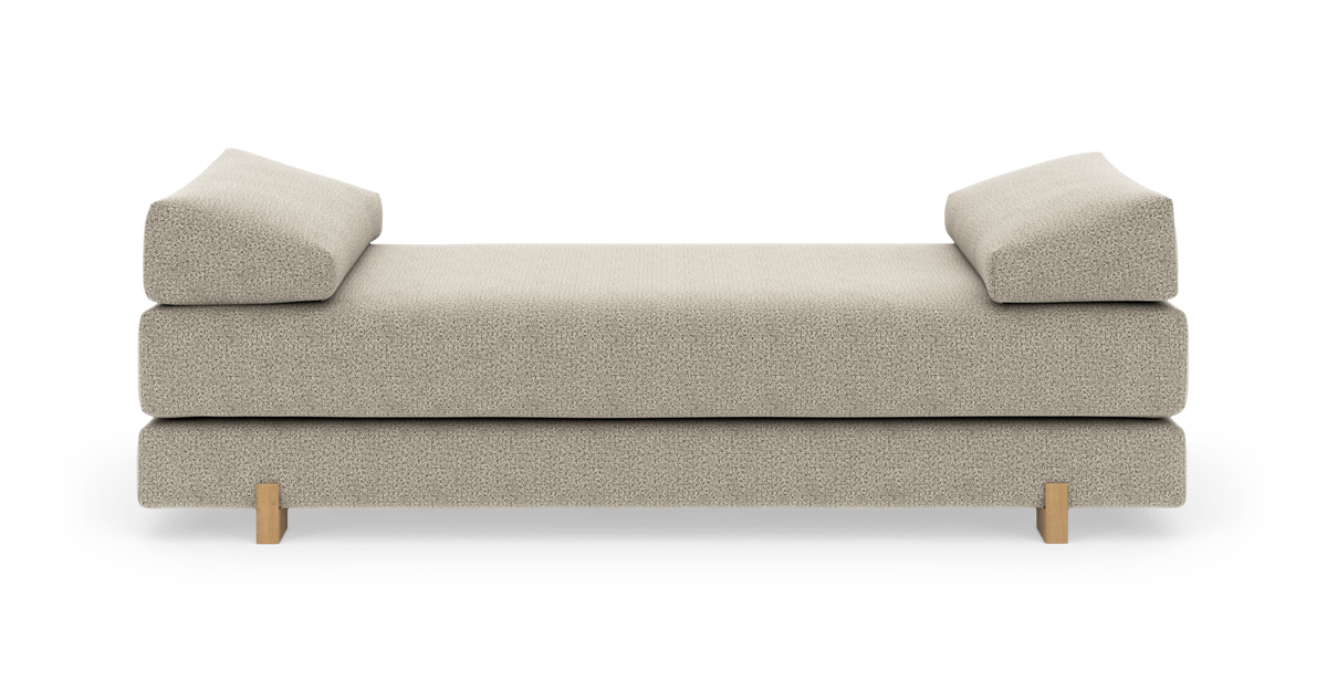 Beige dagbädd med vinklade armstöd och träben, frilagd på vit bakgrund.