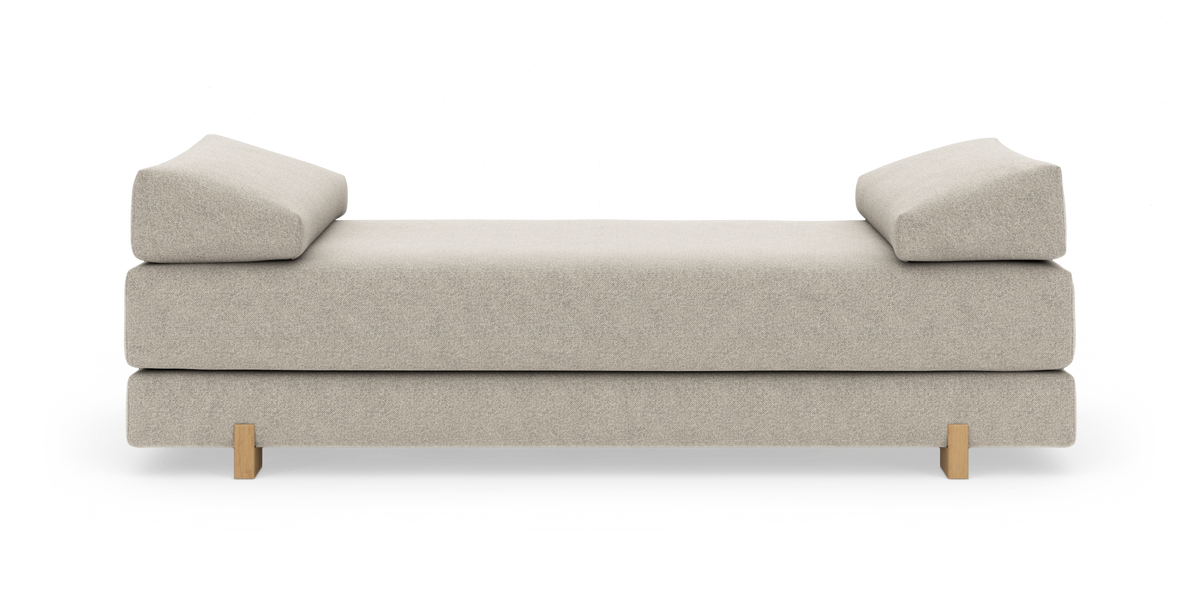 Beige dagbädd med vinklade armstöd och träben, frilagd mot vit bakgrund.