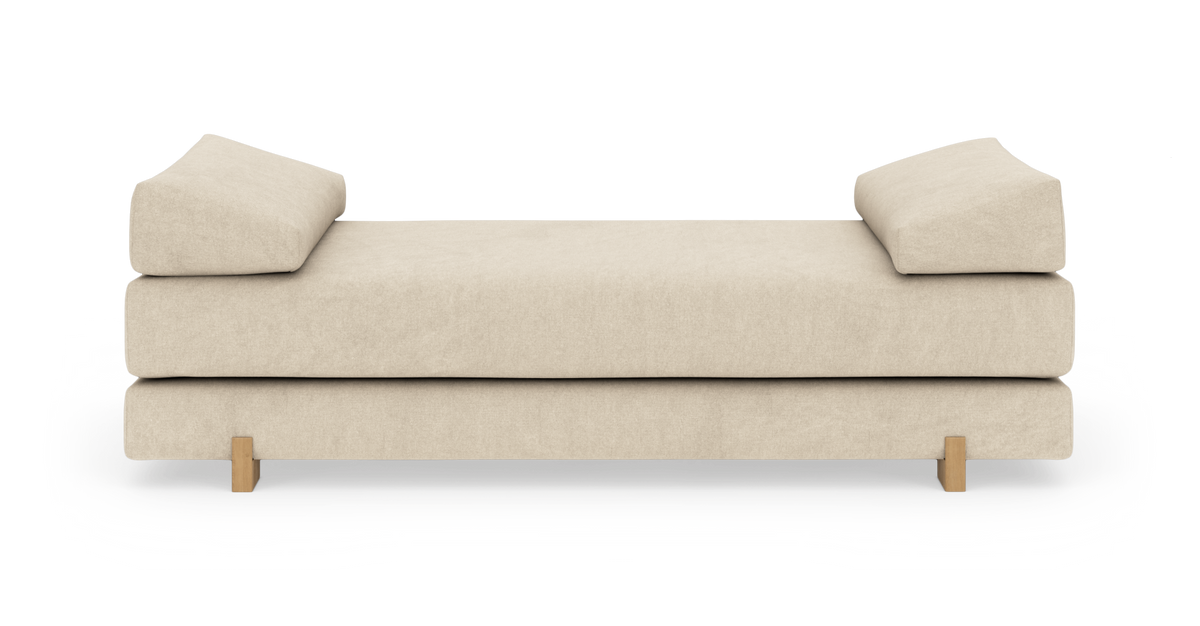 Beige dagbädd med två vinklade ryggkuddar och träben, frilagd på vit bakgrund.