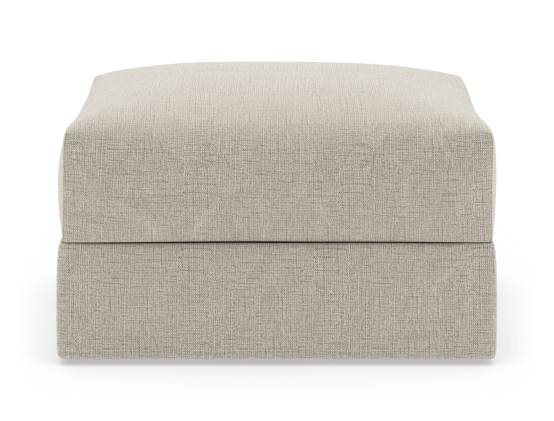 Beige tygklädd ottoman/fotpall i rektangulär form, frontvy mot vit bakgrund.