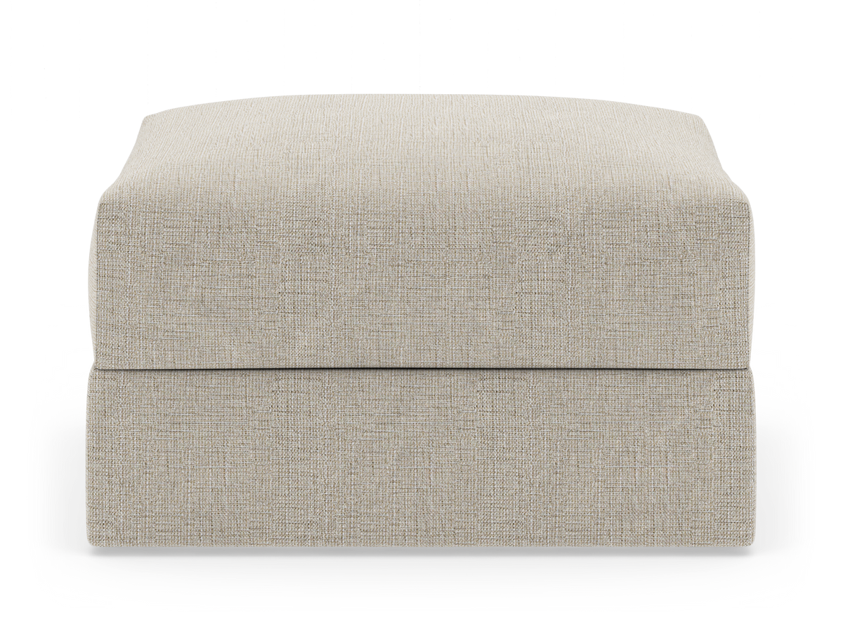 Beige tygklädd ottoman/fotpall i rektangulär form, frontvy mot vit bakgrund.