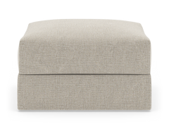 Beige tygklädd ottoman/fotpall i rektangulär form, frontvy mot vit bakgrund.