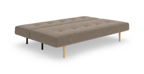 Beige bäddsoffa/daybed i tyg med knapptuftad sits och koniska träben samt svarta stödben, frilagd produktbild i sned frontvy.