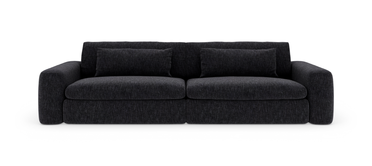 Mörkgrå 3‑sits soffa med rundade armstöd och två avlånga kuddar, frilagd mot vit bakgrund.