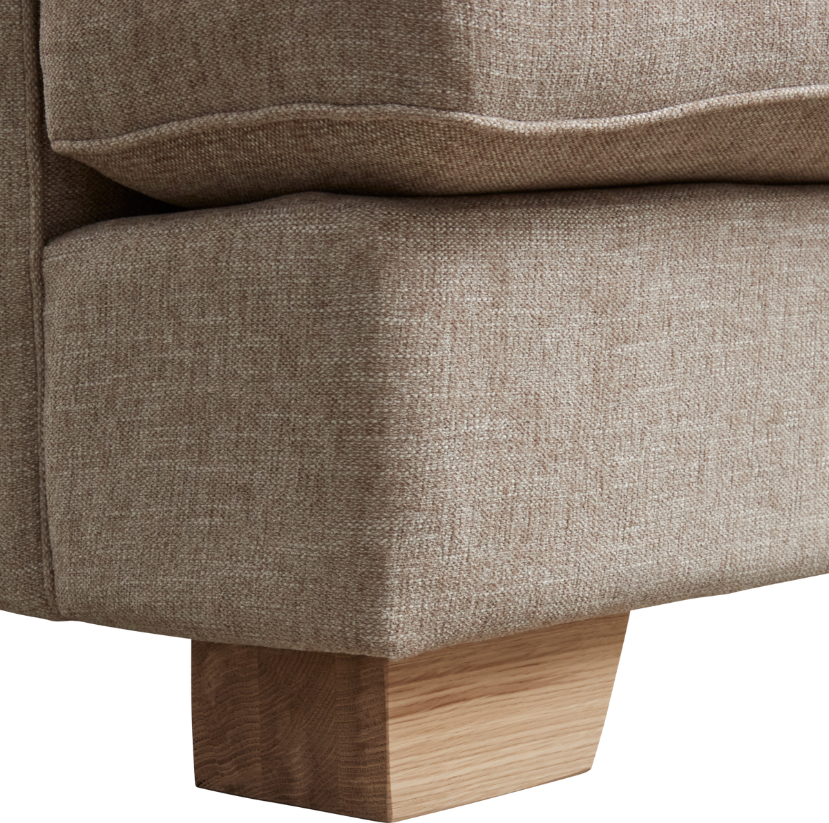 Närbild av beige soffhörn i tyg med blockformad träfot i ljust trä.