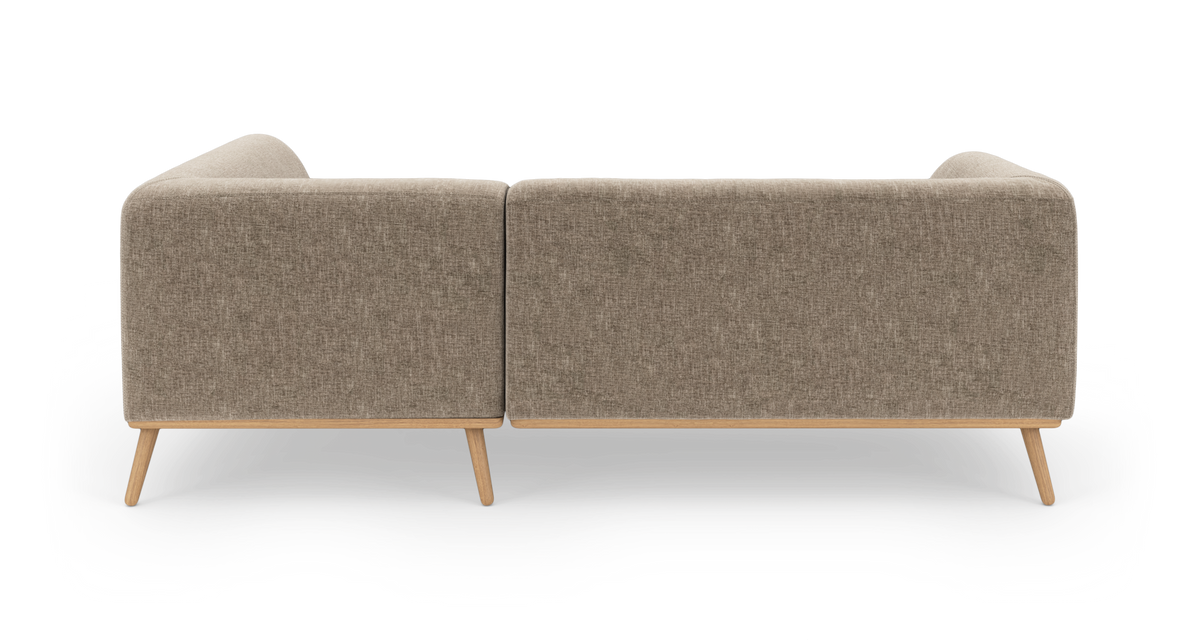 Baksida av beige modulsoffa i tyg med ljusa träben, frilagd mot vit bakgrund.