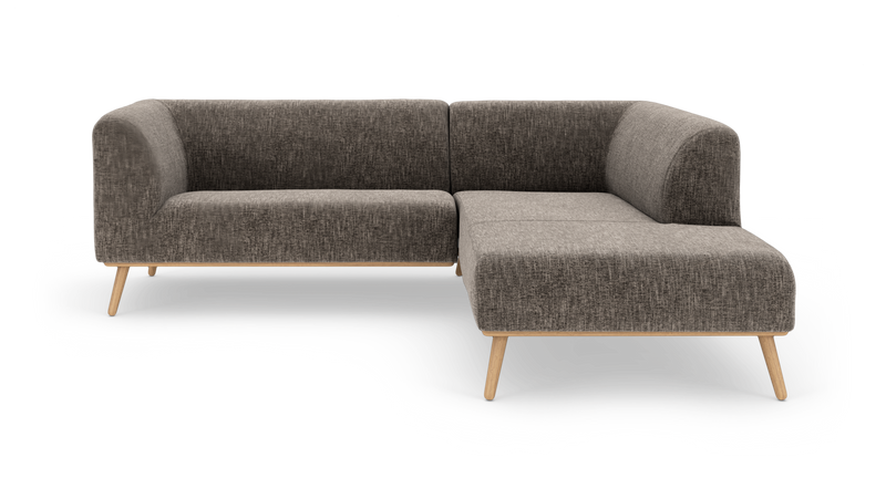L‑formad modulsoffa i mörkgrå textil med ljusa träben, frilagd på vit bakgrund._ps