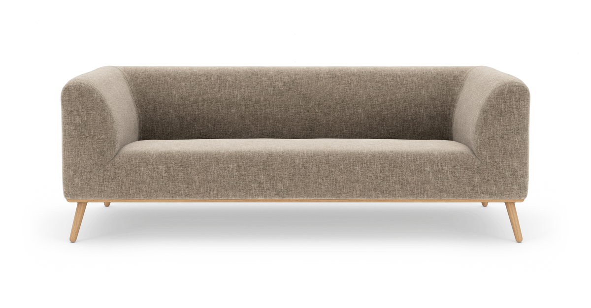 Beige tygsoffa med rundade hörn och träben, frontvy i studiobelysning.