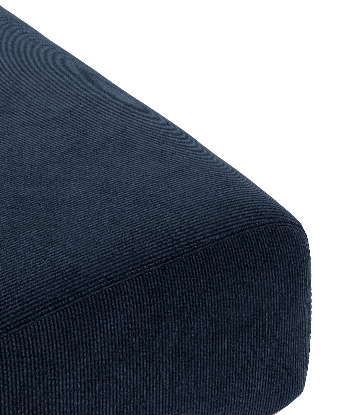 Närbild av mörkblå, ribbad textil på en avrundad sittkudde/soffhörn.