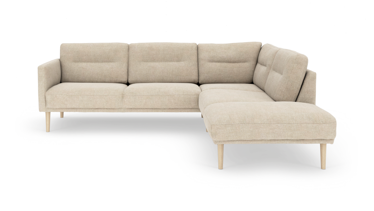 Beige L-formad modulsoffa med schäslong till höger och ljusa träben.