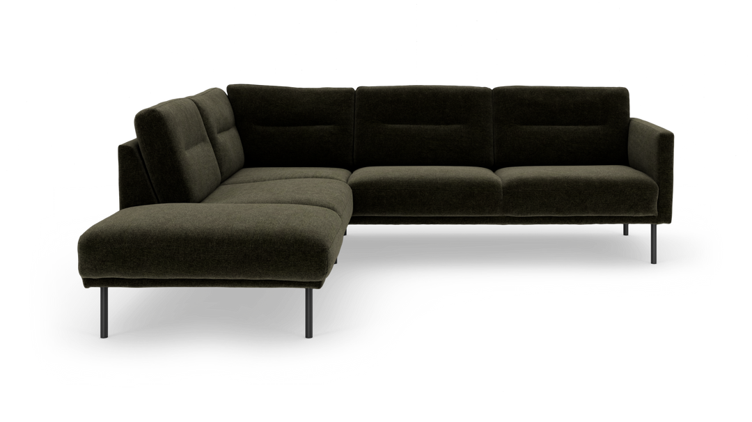 Mörkgrön L‑soffa med metallben i modern, låg design frilagd på vit bakgrund.