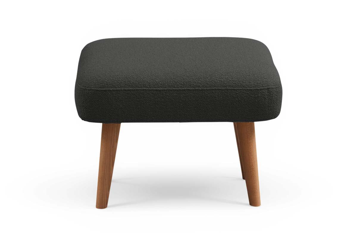 Mörkgrå fotpall med tygklädd sits och koniska ben i trä, frilagd på transparent bakgrund.