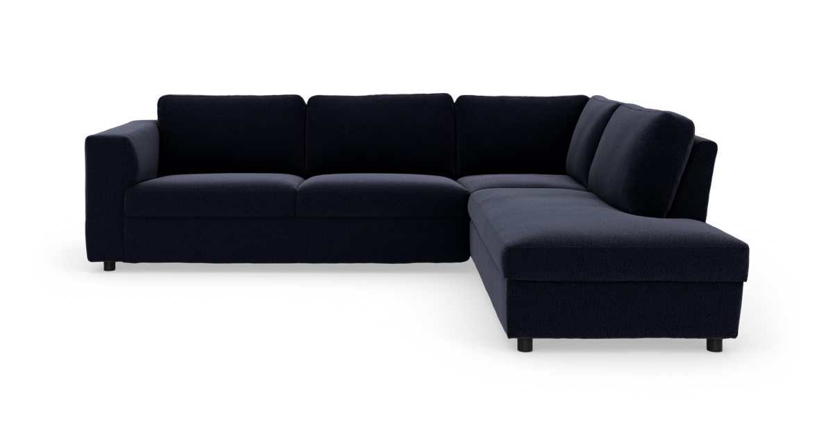Mörkblå hörnsoffa med schäslong till höger i modern design, frilagd mot vit bakgrund.